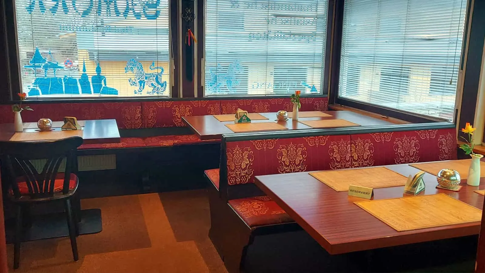 A booth with bench seating and a table by the window